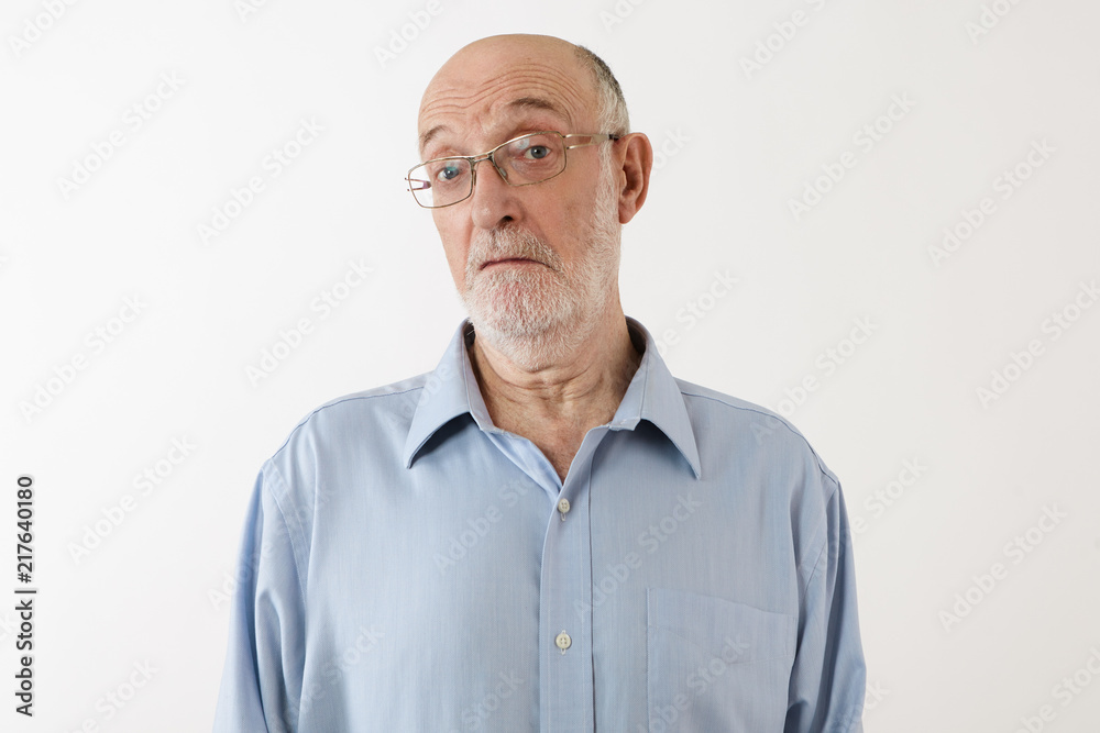 Picture of emotional elderly man with gray beard and bald head staring at camera with clueless facial expression, being at loss. Senior male in eyeglasses posing in studio, feeling confused Picture of emotional elderly man with gray beard and bald head staring at camera with clueless facial expression, being at loss. Senior male in eyeglasses posing in studio, feeling confused