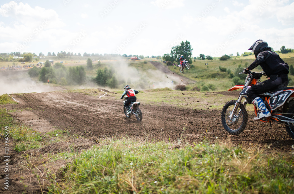 A picture of a biker doing a trick, and jumping into the air. Motocross Championship. sports fast driving. bike large small.