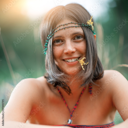 Portrait of a Woodstock Hippie style girl. With flower in the mouth