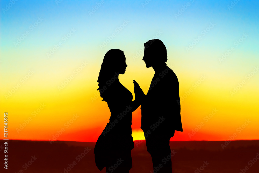 silhouette of a guy and a girl at sunset