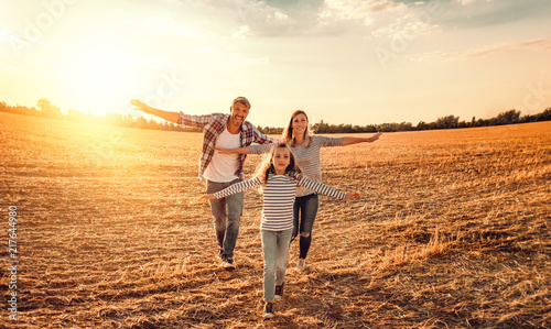 familie mit tochter rennt übers Feld