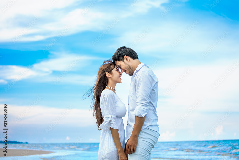 Young couple in love at sea beach on blue sky .happy smiling young Romantic head to head