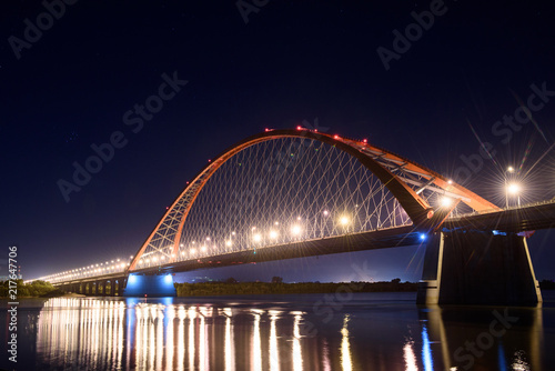 Bridge over the river Ob night. The lights of the bridge glow in the night sky. 