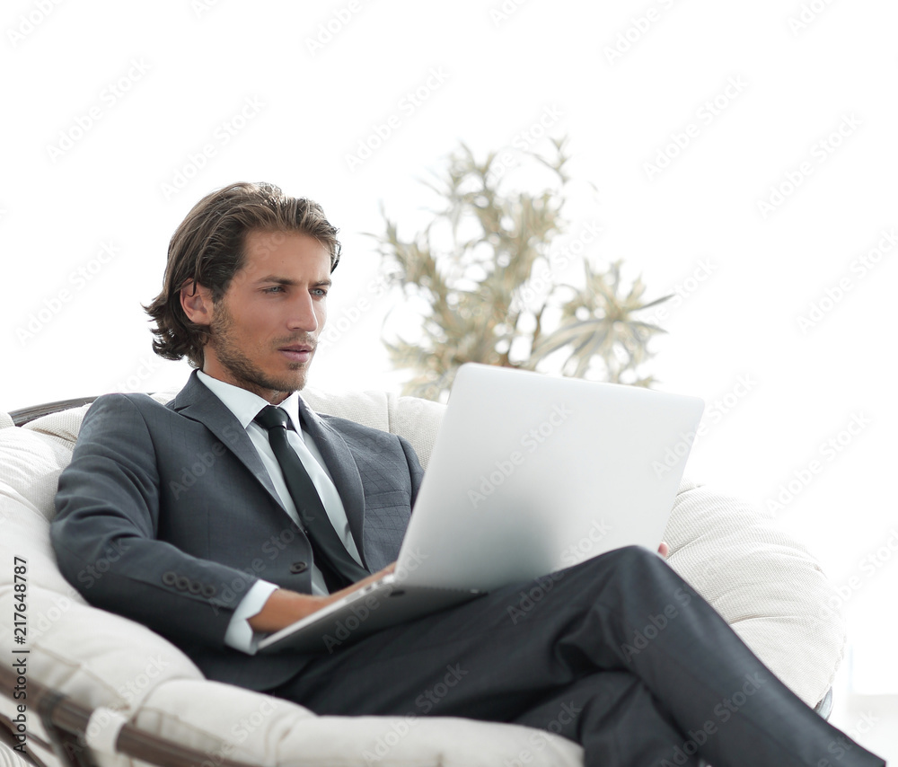 successful businessman with laptop sitting in a large comfortable armchai successful businessman with laptop sitting in a large comfortable armchai