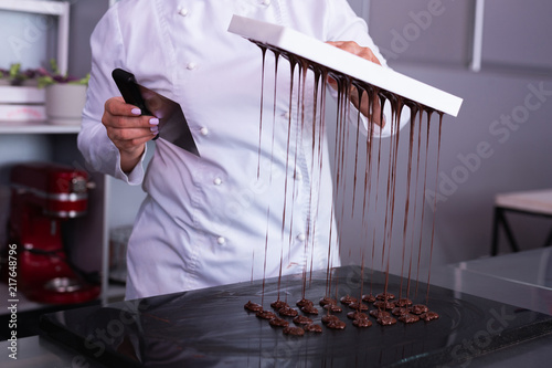 Chocolate sweets. Professional chocolatier feeling very busy while making nice little chocolate sweets photo