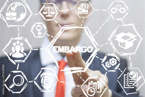 Businessman or politician clicks a embargo text button on a virtual panel. Embargo business finance politics concept.