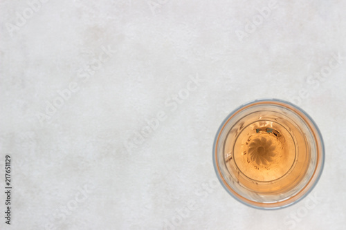 Glass of rose pink wine on light grey background