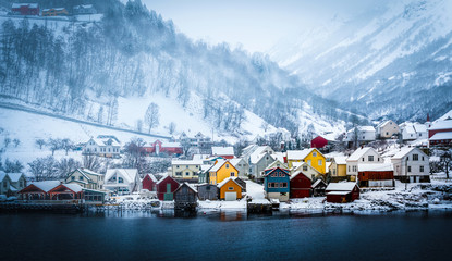wooden houses on the banks of the Norwegian fjord, beautiful mountain landscape in winter