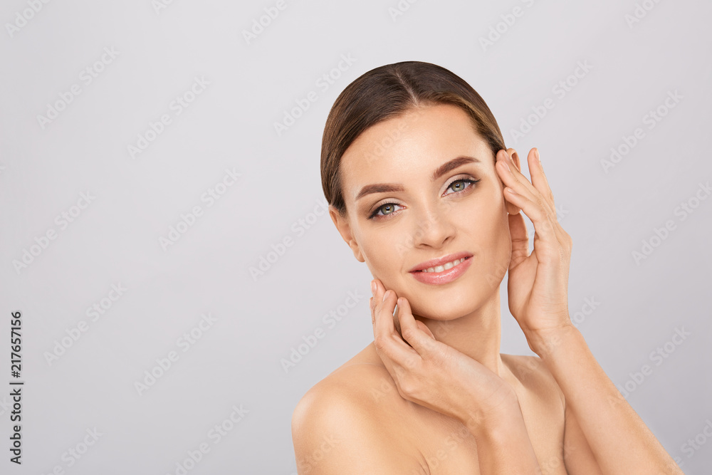 Portrait of beautiful woman with natural make up touching her face. Beauty young woman with fresh clean perfect skin. Skin care concept. Cosmetology, beauty and spa. Facial treatment. Natural skin. Portrait of beautiful woman with natural make up touching her face. Beauty young woman with fresh clean perfect skin. Skin care concept. Cosmetology, beauty and spa. Facial treatment. Natural skin.