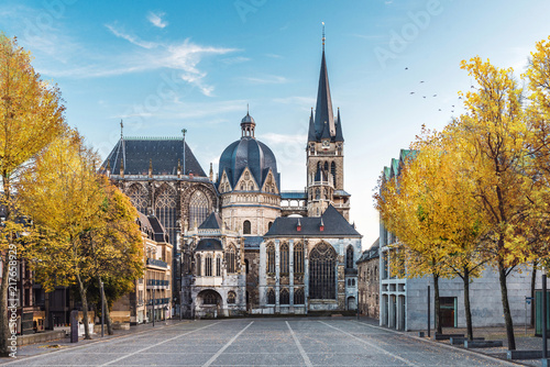 German cathedral in Aachen during fall with yellow leafs at trees with blue sky