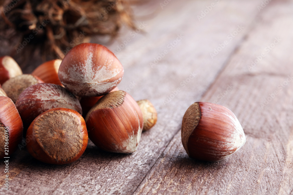 Fototapeta premium Hazelnut on wooden background. Tasty group of organic hazelnuts