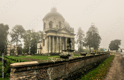 Misty view of Roman Catholic church Exaltation of the Holy and St. Joseph near Pidhirtsi village, Lviv, Ukraine. Old church in couryside at dawn
