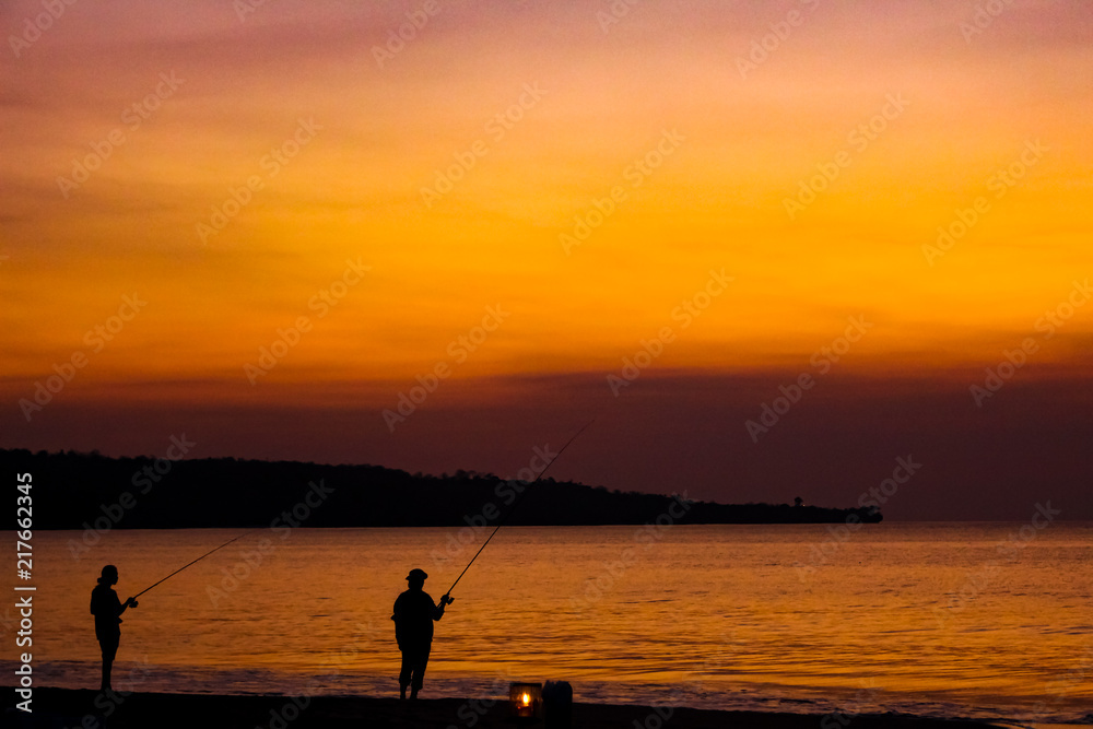 Fishermen on the beach on the island of Bali at sunset.