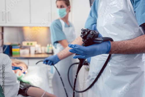 Team of doctors performing endoscopy in hospital examining stomach of patient 
