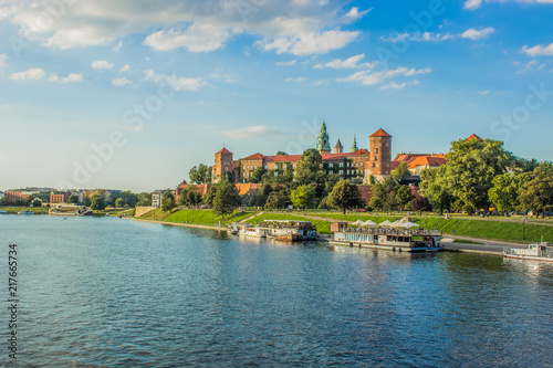 architecture and tourism for wallpaper concept of medieval beautiful castle near river in waterfront old city district in bright colorful day time on blue sky background
