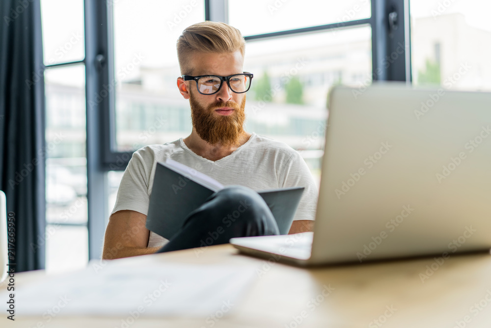 Fototapeta premium Handsome businessman working with laptop in office.