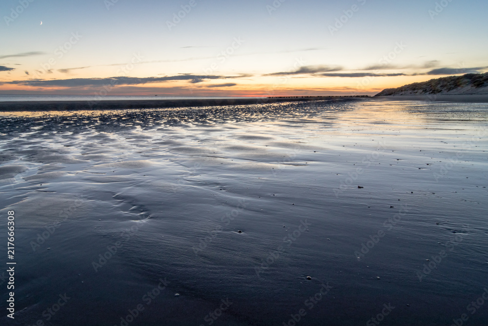 Am Meer, weite Wattlandschaft, Strandimpression nach Sonnenuntergang in Zeeland, Niederlande