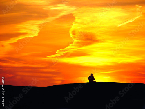 Man on sunset background and orange sky