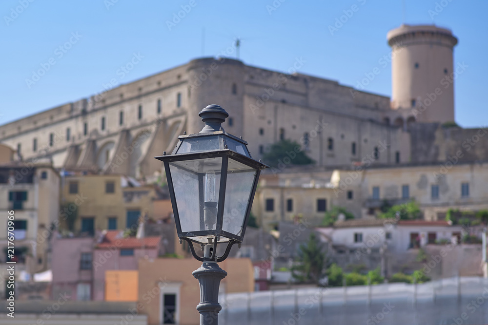 An old street lamp on the background of an old fortress