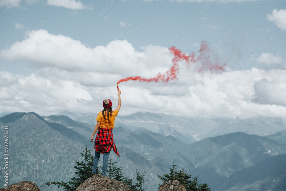 Woman on mountain peak with red flare.Inspiration concept. - obrazy, fototapety, plakaty 