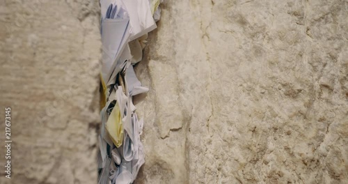 Man's hand put a note between the western wall bricks