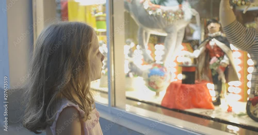 Little preteen girl checking out beautiful shop window decorated with toy circus performers vídeo de Stock | Adobe Stock 