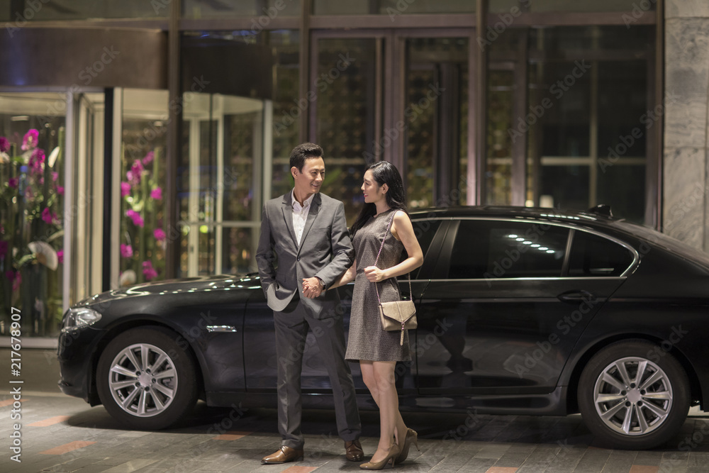 Cheerful young couple arriving at hotel by car Cheerful young couple arriving at hotel by car