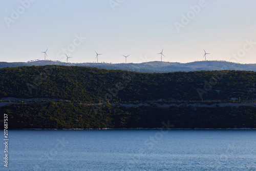 Wind turbines on hill above the sea. Copy space © nedim_b
