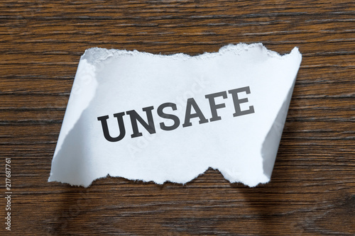 unsafe - an inscription on a piece of white paper, a scroll. The concept of violation of safety precautions, irresponsibility, clumsiness.