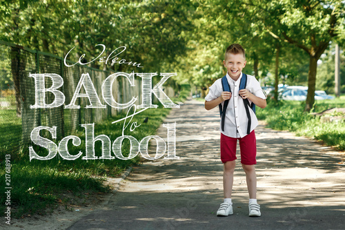 Inscription - Back to school. A portrait of a boy from an elementary school with a backpack on the street. The concept of the day of knowledge  September 1  the beginning of school.
