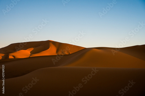 Sand dunes in Sahara desert during the sunny day with the blue sky