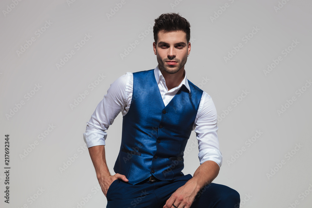 relaxed stylish man wearing a blue vest Photos | Adobe Stock