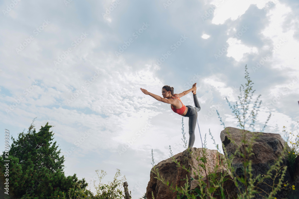 Legs and arms. Sportswoman feeling simply amazing while stretching her legs and arms standing on one leg Legs and arms. Sportswoman feeling simply amazing while stretching her legs and arms standing on one leg