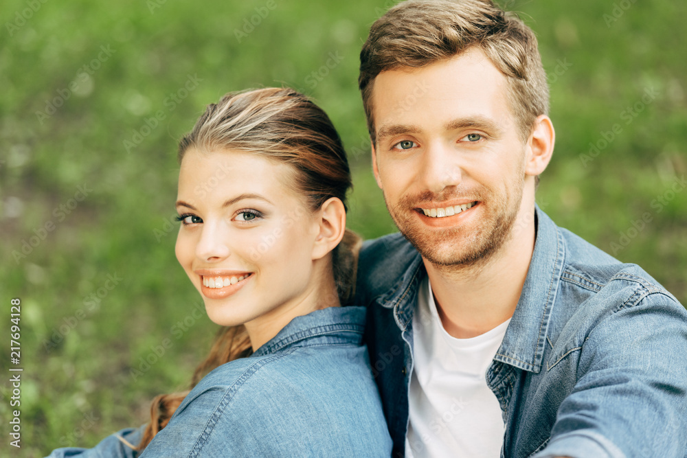close-up portrait of happy young couple spending time together at park and looking at camera close-up portrait of happy young couple spending time together at park and looking at camera