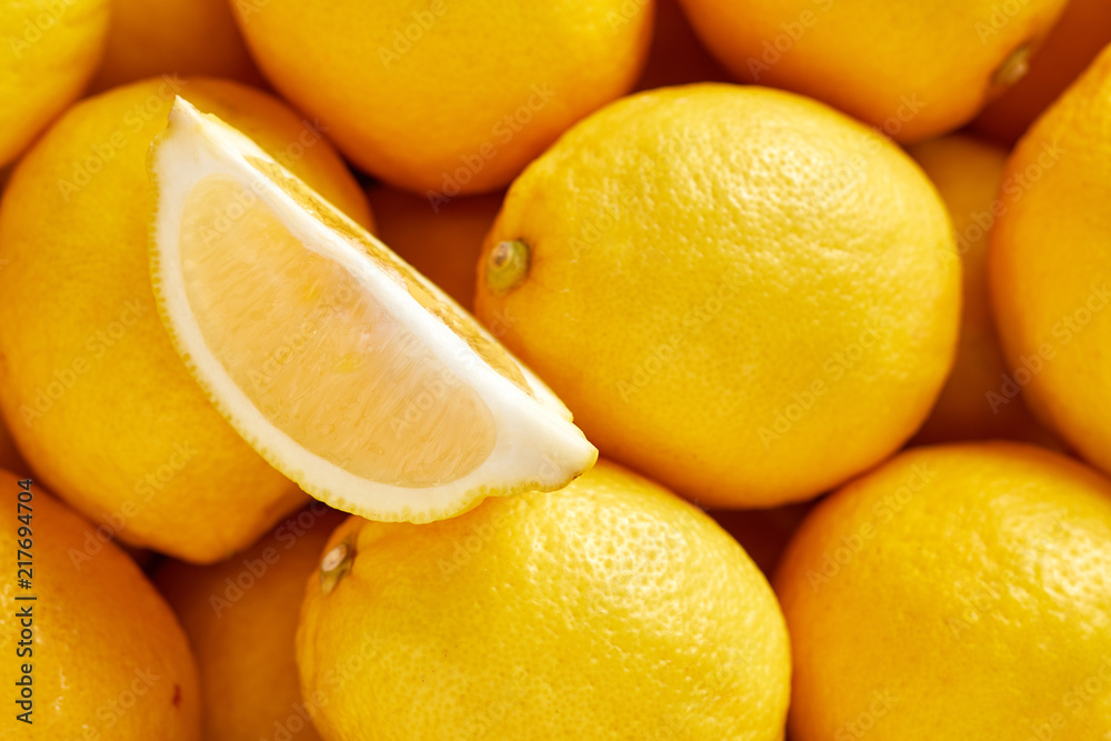 Bunch of fresh lemons in the organic food market. One lemon cutted