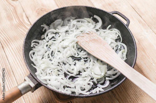 Fried onions in a frying pan. Roasting the chopped onion in oil. photo