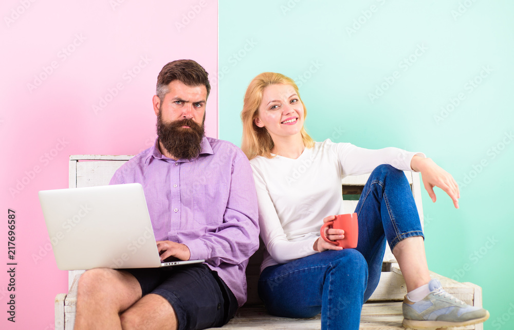 Man works as internet technologies expert on freelance. Freelance benefits. Girl enjoy drink while husband freelancer works with laptop. Woman smiling face drink tea or coffee near man working Man works as internet technologies expert on freelance. Freelance benefits. Girl enjoy drink while husband freelancer works with laptop. Woman smiling face drink tea or coffee near man working