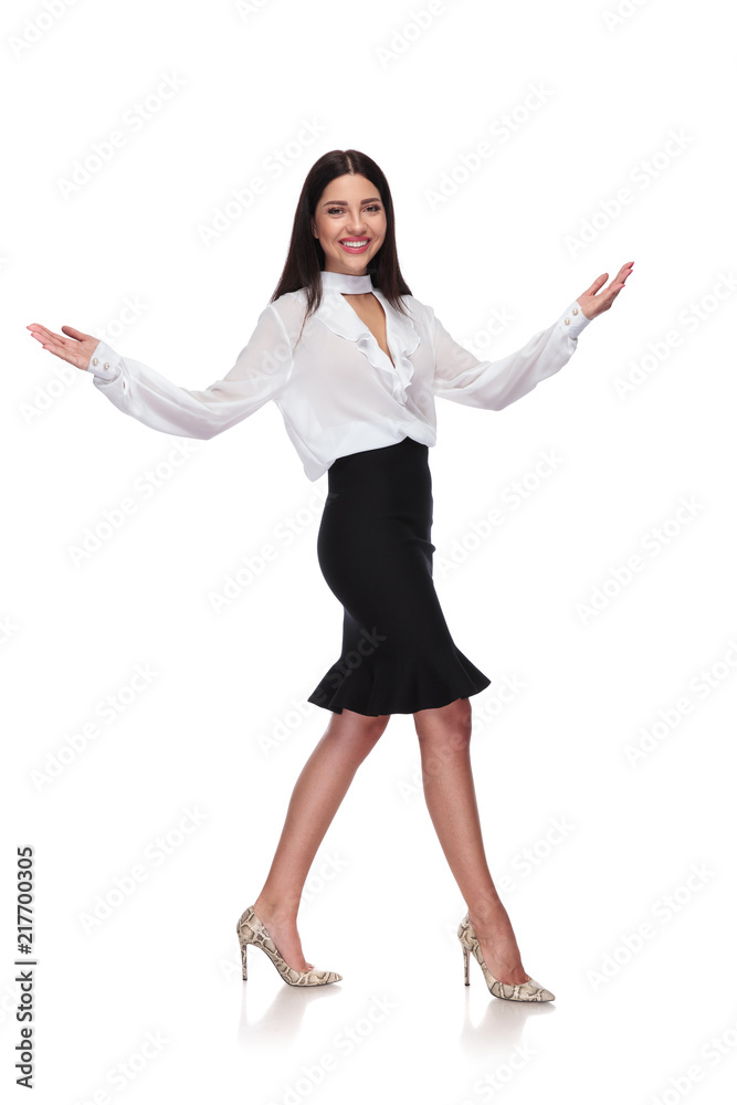 smiling businesswoman walking to side and making a welcoming gesture smiling businesswoman walking to side and making a welcoming gesture