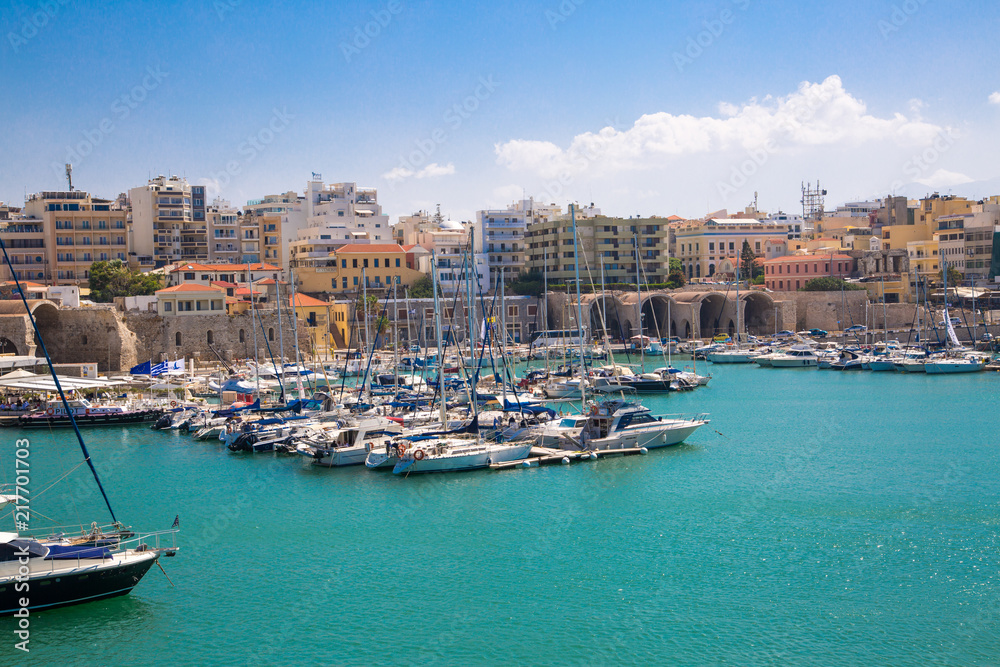 Greece, Crete, Heraklion view from the water. Old venetian harbor of Koules Fortress with fisherman boats and yacht