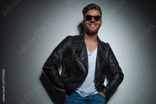 joyful man wearing a black leather jacket and sunglasses