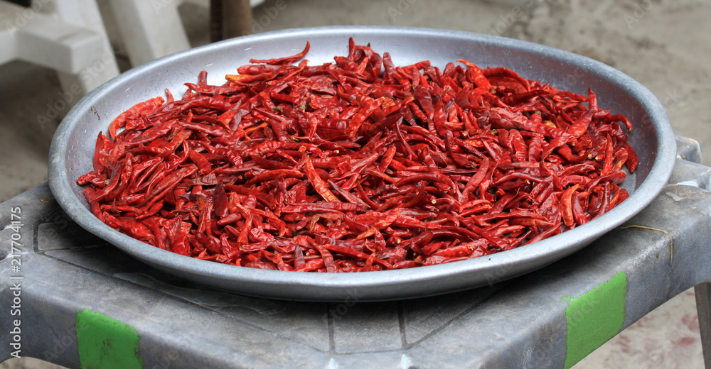 Naklejka premium Chilli. Fruits of red hot pepper on a large aluminum bowl.