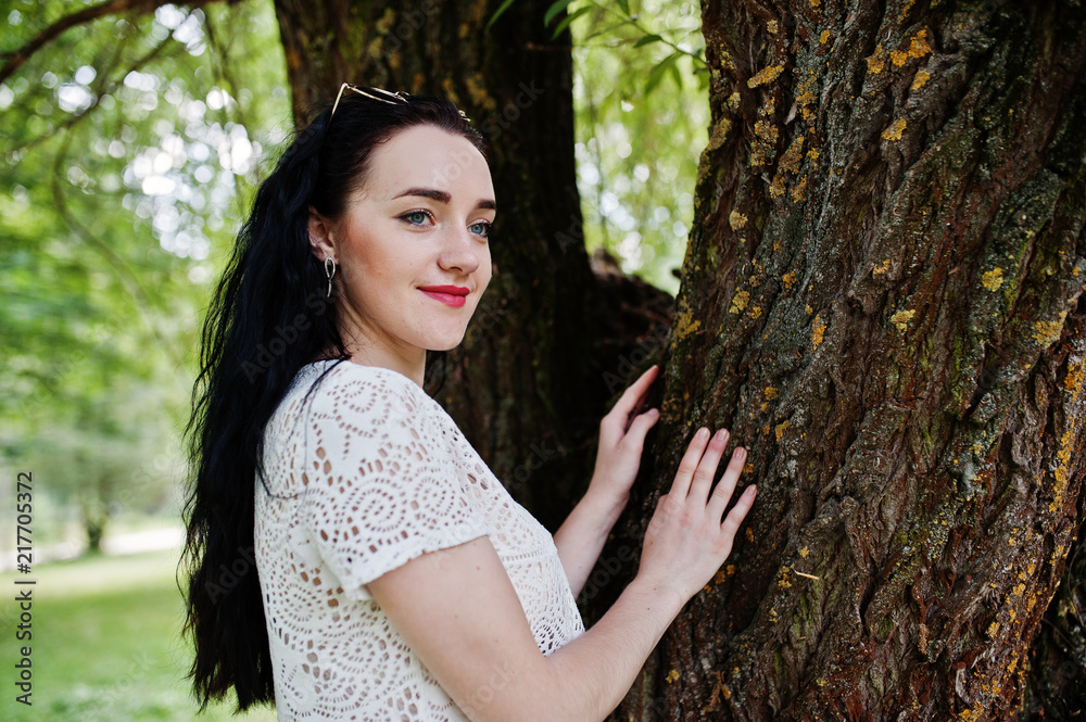 Brunette girl in green skirt and white blouse posed at park. Brunette girl in green skirt and white blouse posed at park.