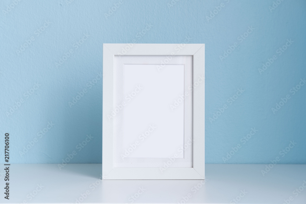 blank white picture frame on the table with blue background blank white picture frame on the table with blue background