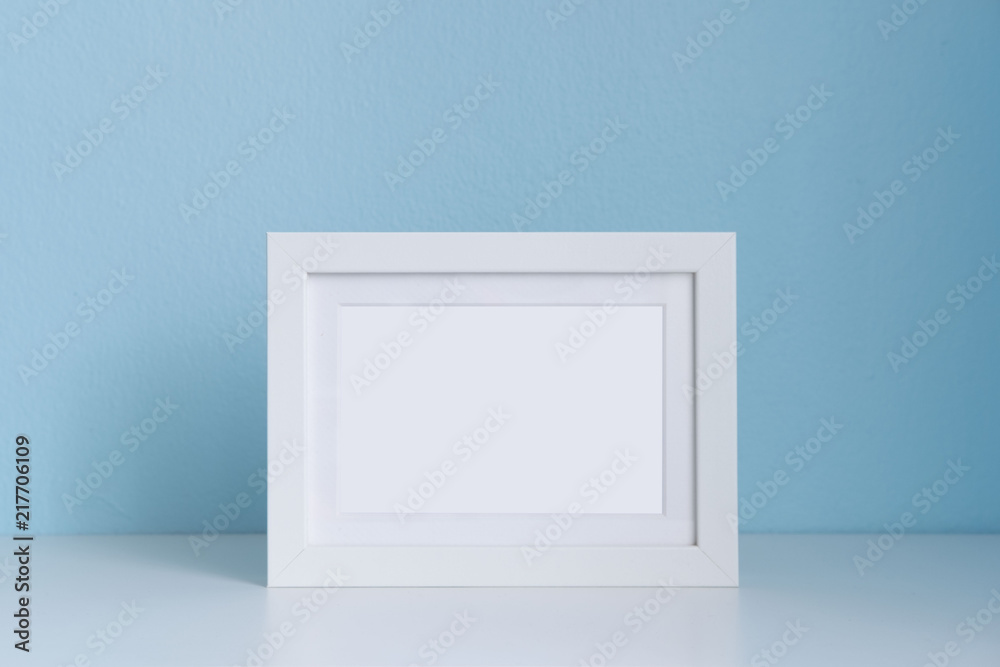 blank white picture frame on the table with blue background blank white picture frame on the table with blue background