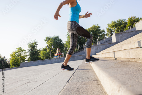 healthy lifestyle sports woman running up on stone stairs sunrise seaside photo