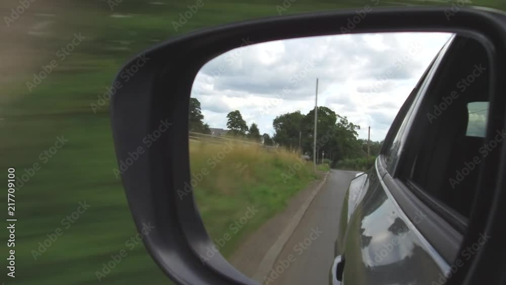 Reflection in a car wing mirror of a drive along a rural road. Reflection in a car wing mirror of a drive along a rural road.