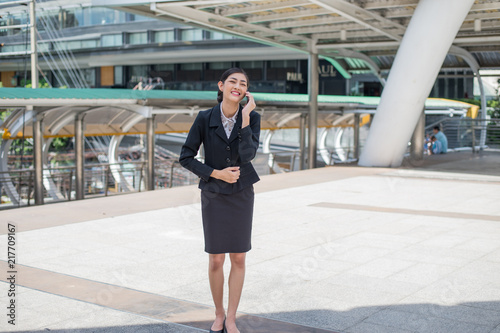 Asian business woman smile and hold cell phone to talk about business success