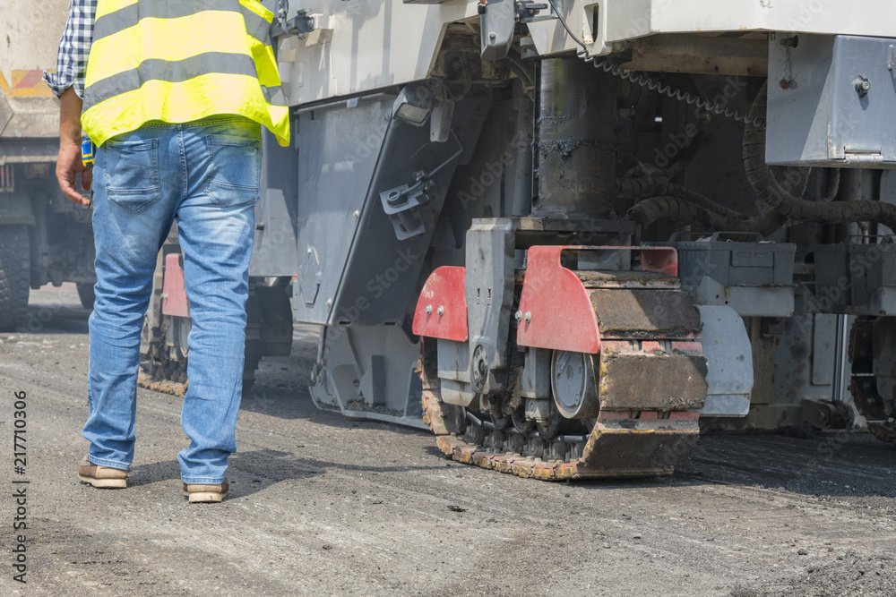 Close view on the workers and the asphalting machines. Machinery for asphalting roads Close view on the workers and the asphalting machines. Machinery for asphalting roads