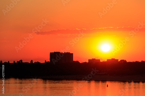 Orange sunset over a river Dnieper in Kremenchug city, Ukraine © olyasolodenko