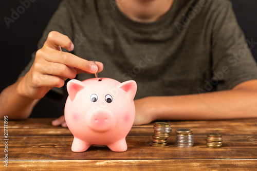 piggy bank savings with hand and people in background